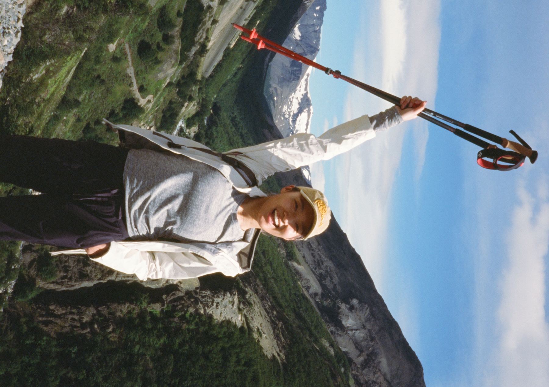 Fuma holding hiking poles in a mountain valley