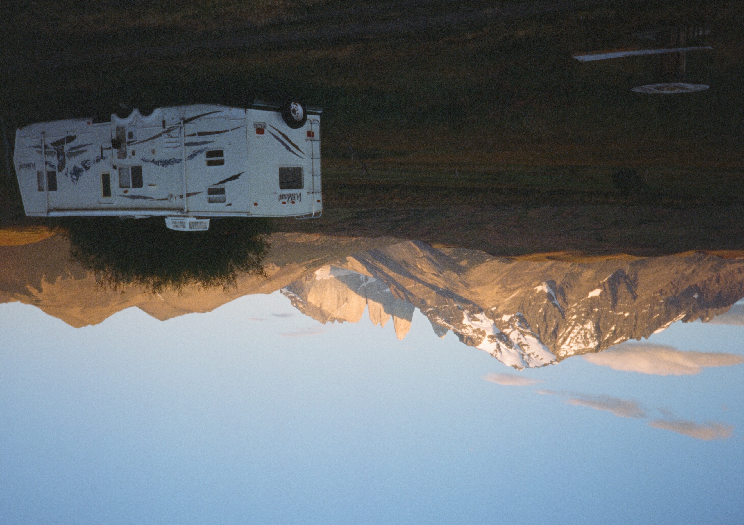 A camper beneath the Torres del Paine massif at dusk