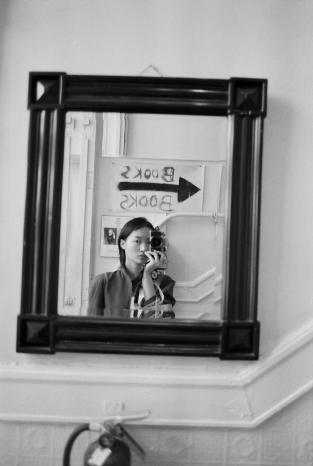 A black and white mirror portrait taken at City Lights Booksellers